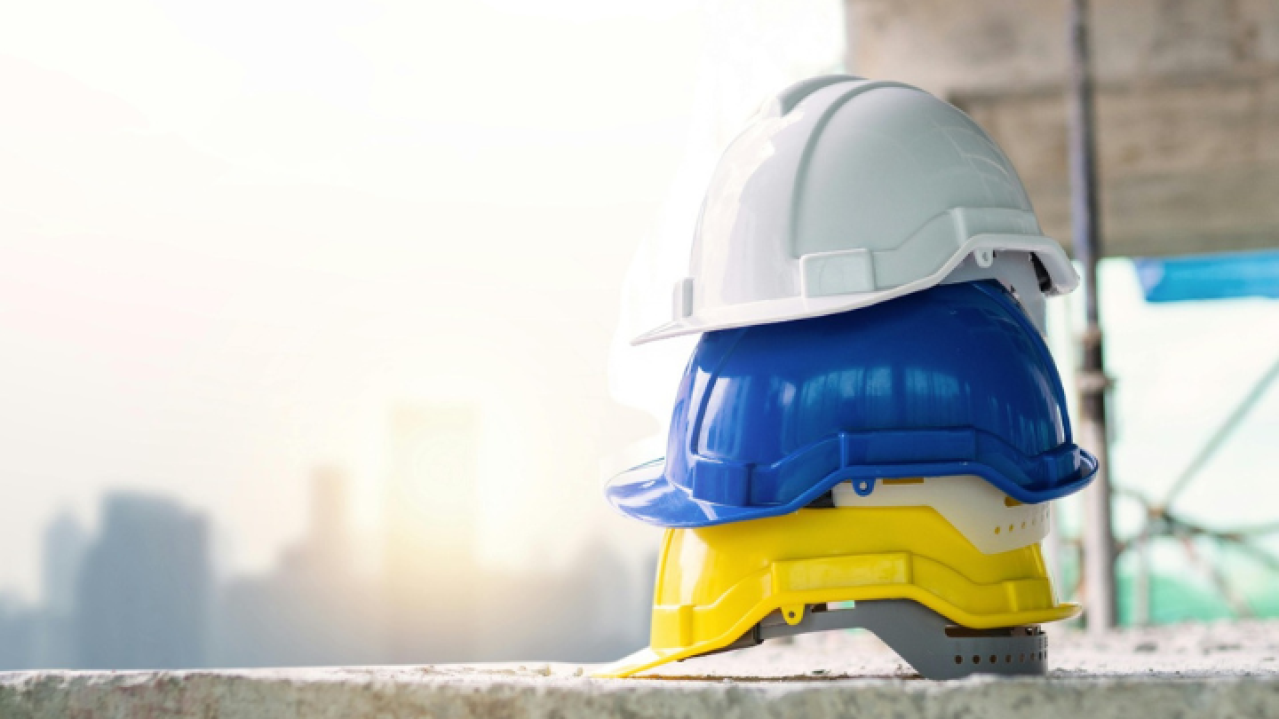 Immagine con tre caschi impilati dispositivo di protezione individuale DPI nei cantieri edili